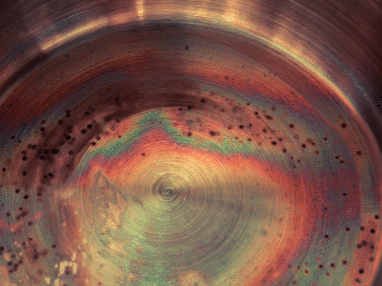 Przebarwienia termiczne i ślady rdzy na dnie garnka ze stali nierdzewnej