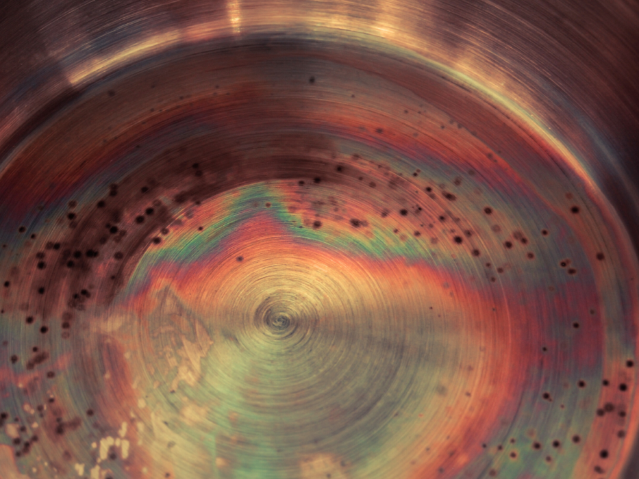 Przebarwienia termiczne i ślady rdzy na dnie garnka ze stali nierdzewnej